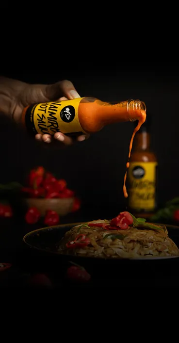 Nai Miris hot sauce being poured over a Sri Lankan noodle dish